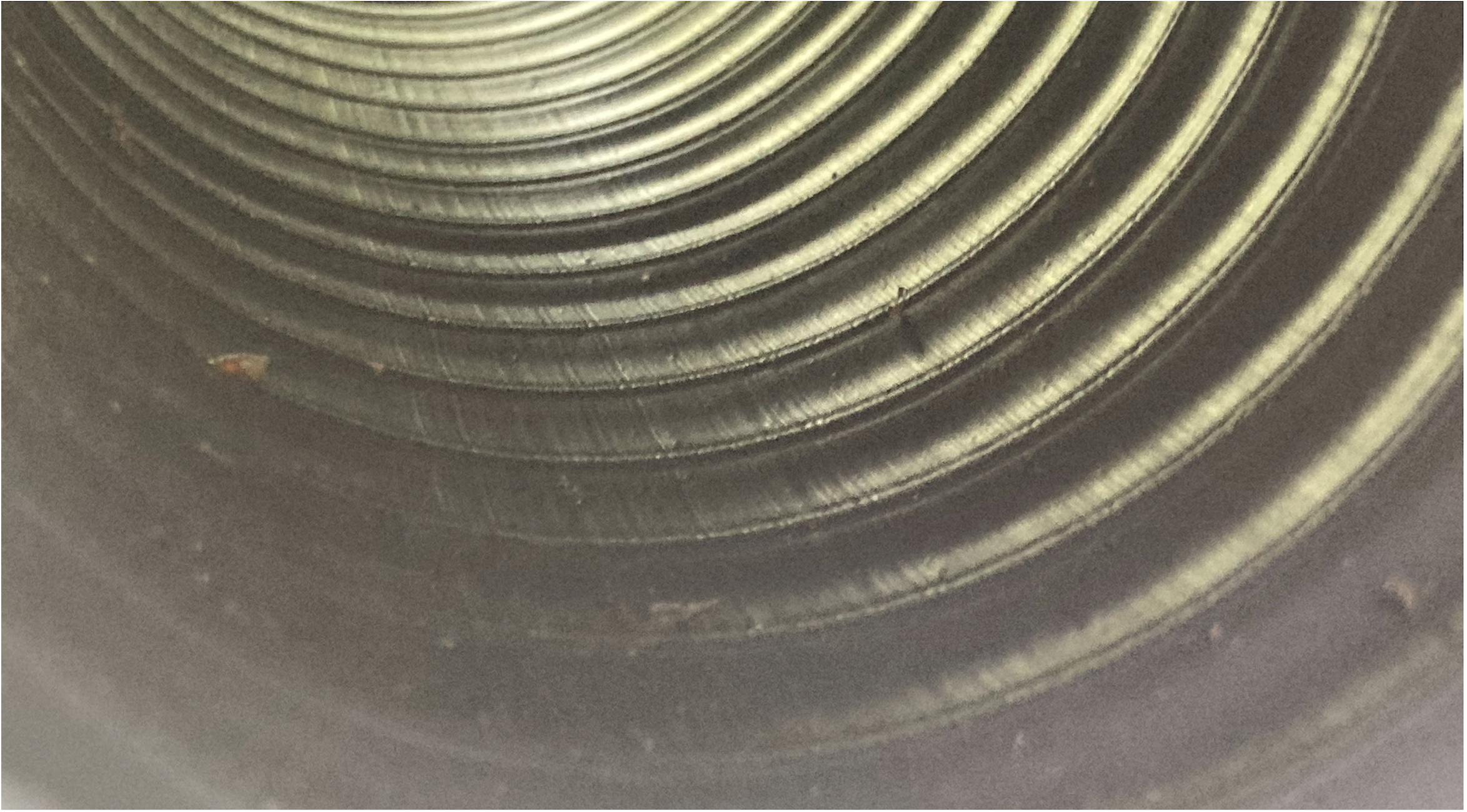 Concentric ridges inside a dark water pipe, a still from Tiny Infiltration.
